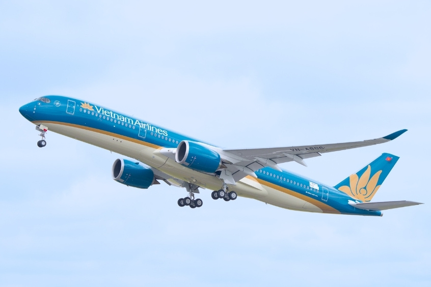 Máy bay Vietnam Airlines mang biểu tượng hoa sen cất cánh dưới bầu trời trong xanh