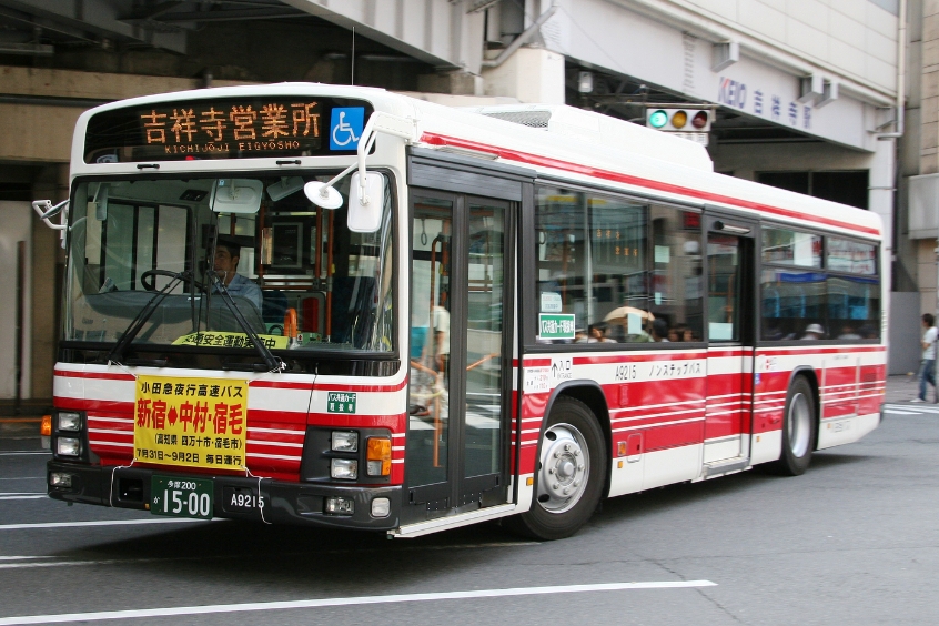 Xe buýt công cộng tại Nhật Bản với biển báo và hành khách lên xuống.