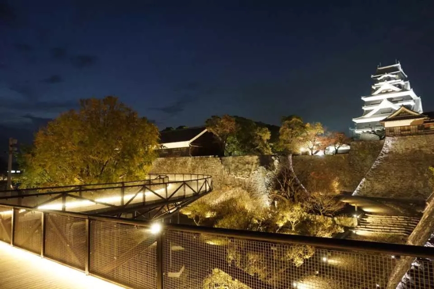 Cảnh thành Kumamoto vào ban đêm, với ánh sáng chiếu sáng khu vực thành cổ.