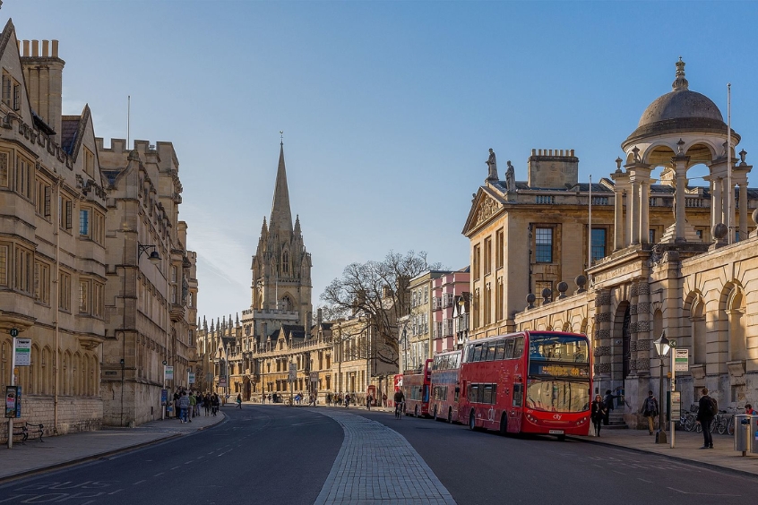 Cảnh đường phố Oxford với tòa nhà cổ kính và xe buýt hai tầng đỏ đặc trưng.