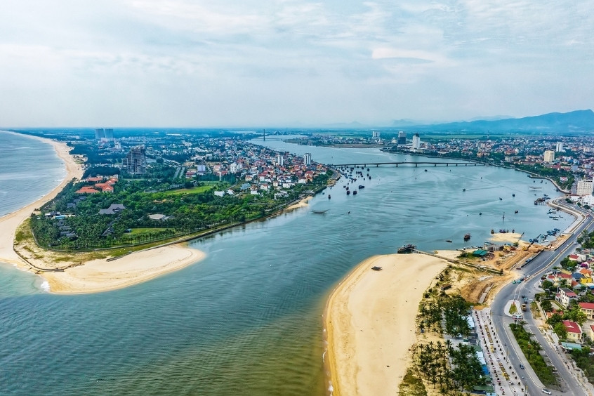 Toàn cảnh thành phố Đồng Hới nhìn từ trên cao, với sông Nhật Lệ uốn lượn, biển xanh và bãi cát trắng trải dài (Nguồn: Internet)