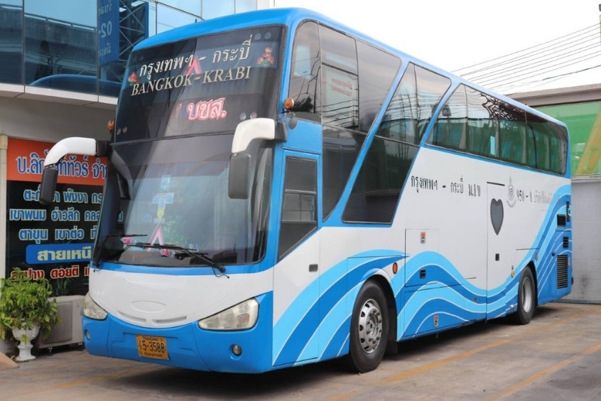 Xe buýt xanh trắng tuyến Krabi đậu tại trạm, với thiết kế sóng nước độc đáo, sẵn sàng phục vụ du khách