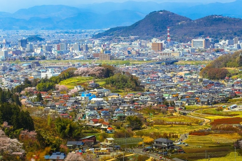 Toàn cảnh thành phố Fukushima với những dãy núi hùng vĩ, cây xanh tươi tốt và các tòa nhà hiện đại