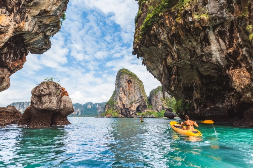 Người chèo kayak khám phá hang động và vách đá vôi tại Krabi, giữa khung cảnh biển xanh và thiên nhiên hùng vĩ