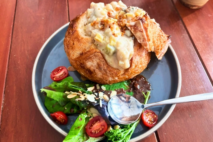 Món súp nghêu Clam Chowder nổi tiếng của San Francisco trong bánh mì chua, kèm salad rau xanh