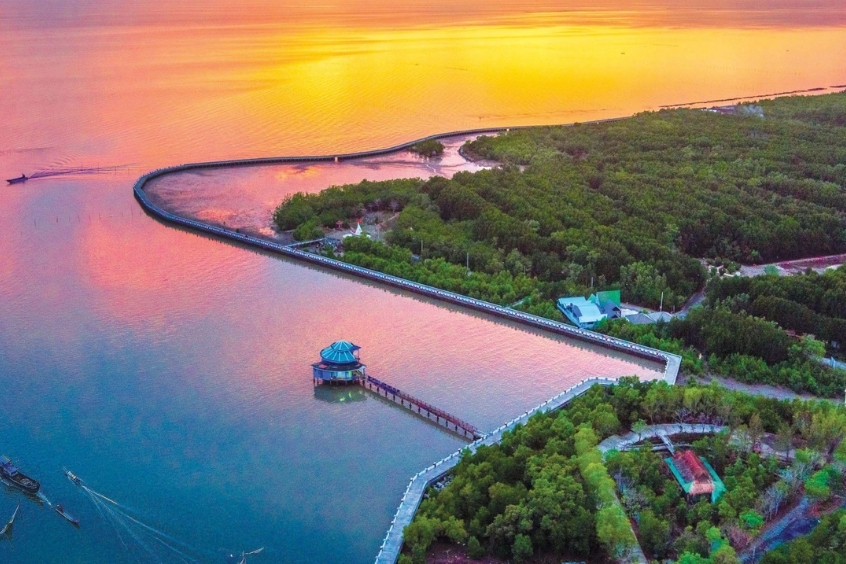 Khung cảnh hoàng hôn rực rỡ tại Cà Mau, ánh nắng vàng cam phản chiếu trên mặt nước yên ả