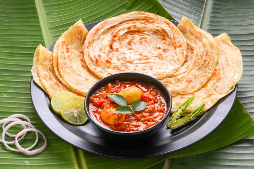  Đĩa bánh Parotta Ấn Độ và cà ri trứng cay trên nền lá chuối