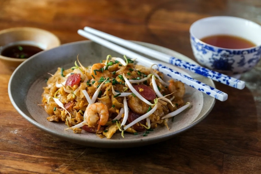 Char Kway Teow bày trên đĩa với tôm, trứng và giá đỗ hấp dẫn