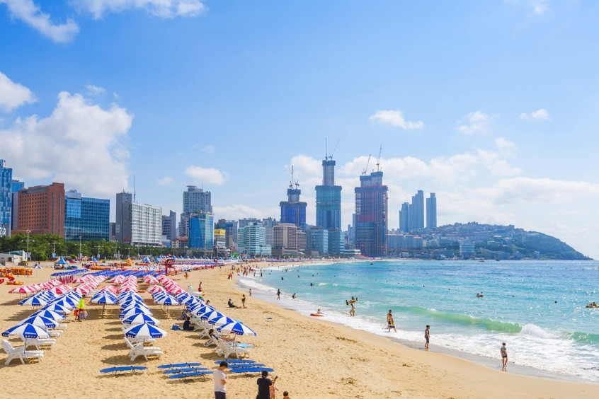 Du khách vui chơi tại bãi biển Haeundae với cát trắng và biển xanh trong