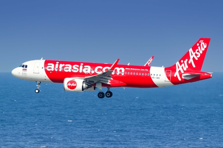 Máy bay AirAsia đang cất cánh với logo đỏ đặc trưng.