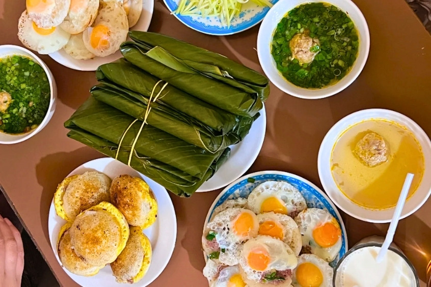 Bánh căn Đà Lạt nóng hổi, vàng giòn, ăn kèm nước mắm hành và xíu mại, món ăn sáng dân dã được yêu thích