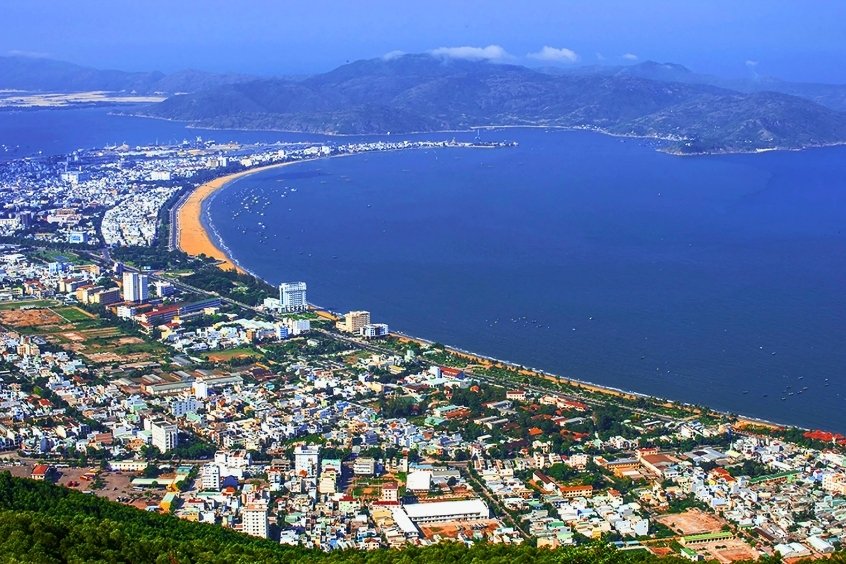 Thành phố Quy Nhơn nhìn từ trên cao với bãi biển cong hình trăng khuyết và khung cảnh thiên nhiên tuyệt đẹp