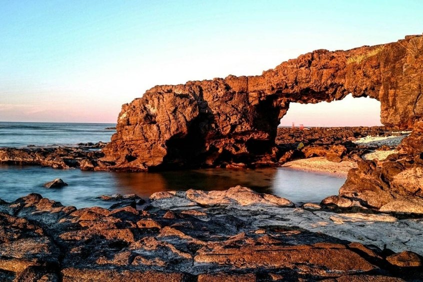 Cổng Tò Vò, biểu tượng đá thiên nhiên độc đáo tại Lý Sơn, nơi du khách thường đến ngắm bình minh và chụp ảnh kỷ niệm (Nguồn: Internet)