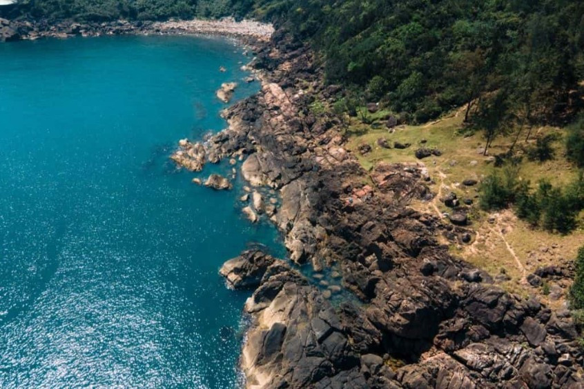 Toàn cảnh bãi đá Đen tại bán đảo Sơn Trà với những tảng đá lớn nằm rải rác bên bờ biển trong xanh