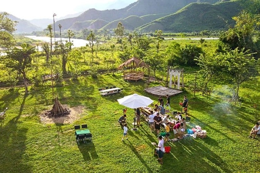 Những chiếc lều trắng trải dài trên thảm cỏ xanh mướt bên cạnh dòng sông Cu Đê êm đềm vào buổi chiều tà