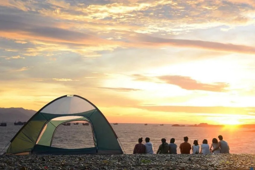 Những túp lều cắm trại nhỏ nhắn dựng trên bãi biển cát trắng hoang sơ của Làng Vân dưới ánh nắng