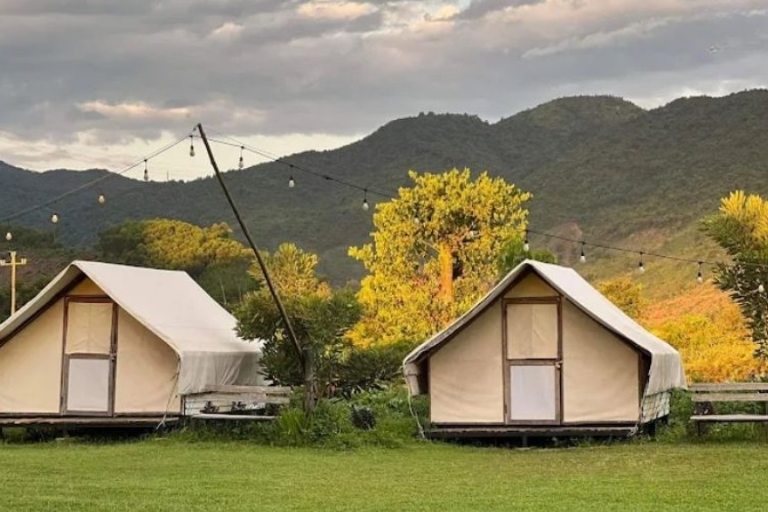 Toàn cảnh khu du lịch Yên Retreat nhìn từ trên cao với thảm cỏ xanh và dòng sông Cu Đê bao quanh