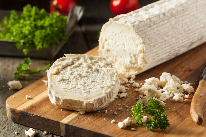 Miếng goat cheese màu trắng mềm mịn được bày cùng rau
