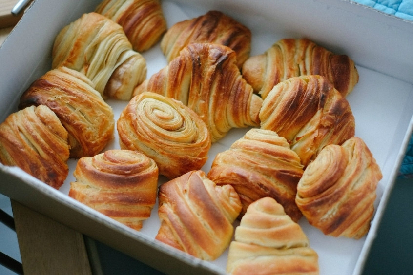 Những chiếc bánh Franzbrötchen xoắn ốc, rắc đường và quế, được bày trên khay nướng