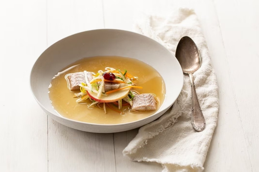 Tô súp lươn màu vàng óng, có những miếng lươn mềm, ăn kèm rau thơm