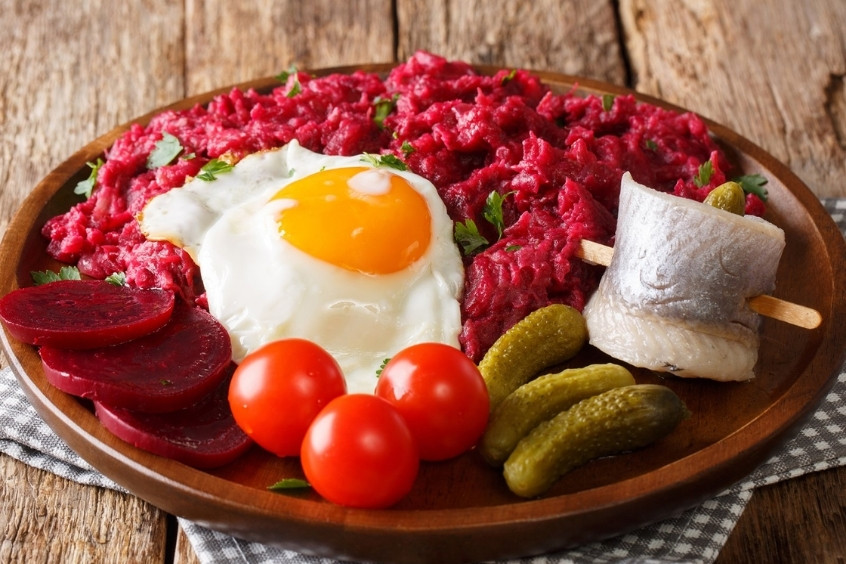 Đĩa Labskaus ăn kèm với trứng chiên, dưa chuột muối và củ dền