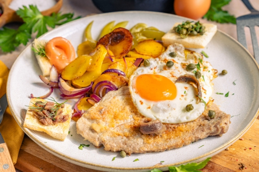 Schnitzel Holstein giòn rụm ăn kèm trứng ốp la và cá trống muối
