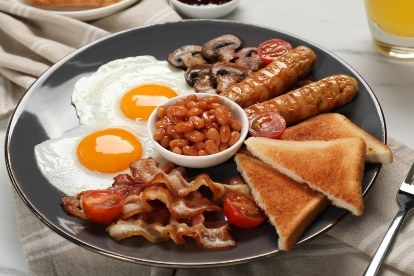 Bữa sáng kiểu Anh đầy đủ trên đĩa với xúc xích, trứng, thịt xông khói và khoai tây